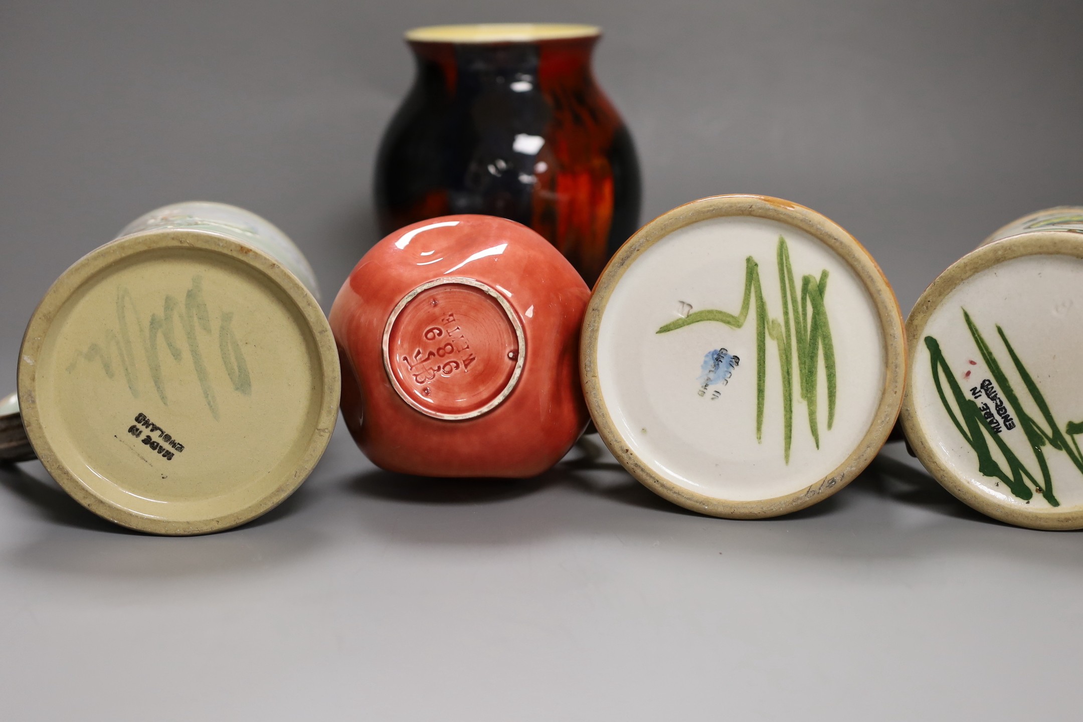 Three Glyn College jugs, a flambé Poole vase and a Burmantoft ‘White’ dimpled vase no. 989, tallest 16.5cm